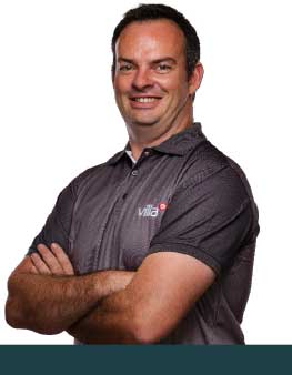 Vivian Butler, Villa agronomist standing confidently with his arms crossed, smiling.