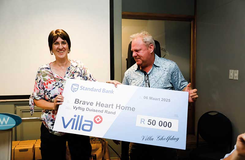 Villa besturende direkteur Marius Boshoff oorhandig ’n skenking aan Gerda de Goede van die Brave Heart-huis vir kwesbare kinders in De Doorns.
